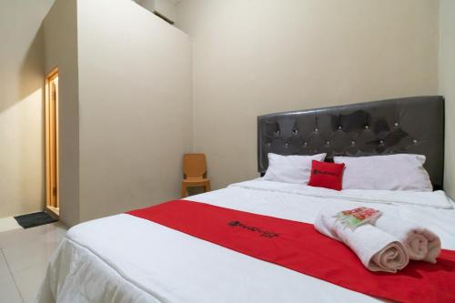 ein Schlafzimmer mit einem weißen Bett mit Handtüchern darauf in der Unterkunft RedDoorz near Palembang Trade Center 4 in Sukarami