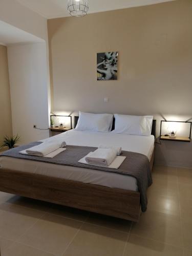a bedroom with a large bed with two lamps at Ionian Golden Sun in Valanidorachi
