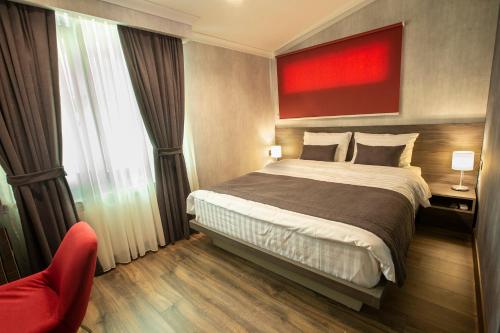 a hotel room with a bed and a red painting at Kope Palace in Tbilisi City