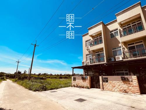 a building with chinese writing on it next to a road at SleepOrNo in Jinning