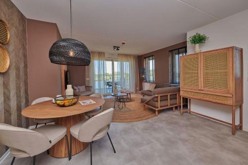 Parc Maasresidence Thorn Apartments في تورْن: غرفة معيشة مع طاولة وكراسي