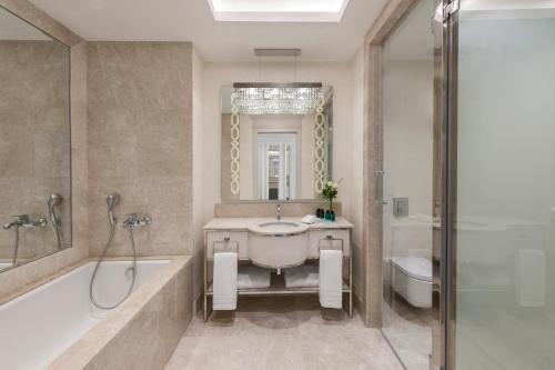 a bathroom with a tub and a sink and a shower at Kaya Palazzo Resort & Casino in Kérynia