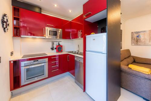 a kitchen with red cabinets and a white refrigerator at Neo in Cala Ratjada