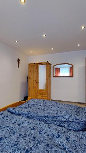 a bedroom with a bed with a blue bedspread at Ferienwohnung Fovere in Kall