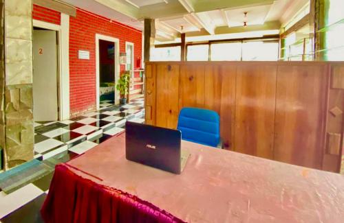a table with a laptop on top of it at Homestay Batu Kelir Syariah Dieng Mitra RedDoorz in Dieng