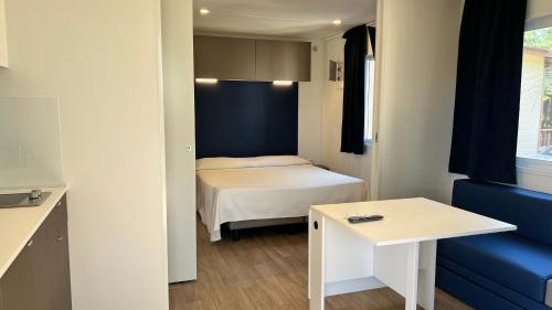 a small room with a bed and a blue couch at Villaggio Dei Fiori in Sanremo