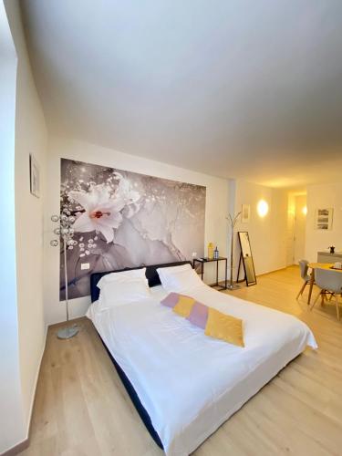 a bedroom with a large white bed with a painting on the wall at Isola Bella Studios in Stresa