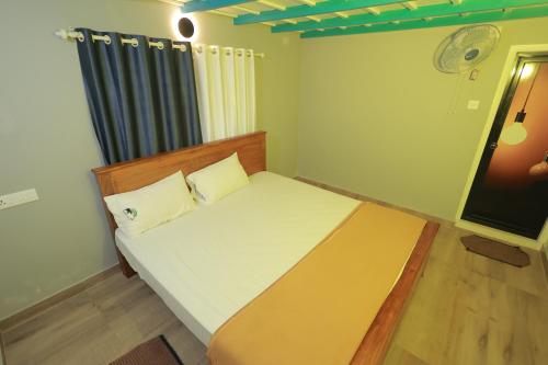 a small bedroom with a bed and a window at Babu's Homestay By Lexstays in Mananthavady