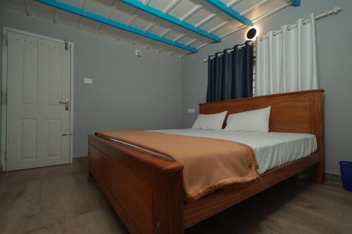 a bedroom with a large wooden bed in a room at Babu's Homestay By Lexstays in Mananthavady