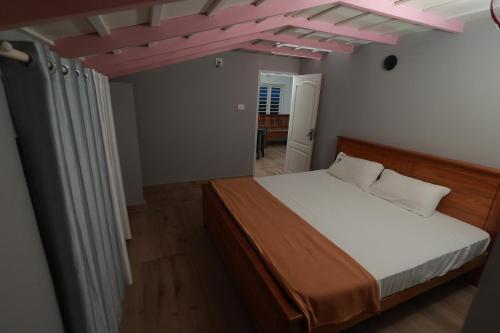 a bedroom with a bed and a pink ceiling at Babu's Homestay By Lexstays in Mananthavady