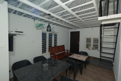 a dining room with a table and chairs at Babu's Homestay By Lexstays in Mananthavady