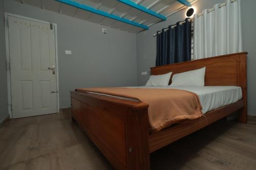 a bedroom with a large wooden bed in a room at Babu's Homestay By Lexstays in Mananthavady