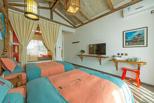 sala de estar con 3 camas y TV en Old Story Inn Dali Ancient Town, en Dali