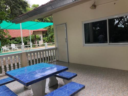 a patio with a blue bench and a table at Saiyok River House in Sai Yok