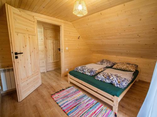 een slaapkamer met een bed in een blokhut bij Domki nad rzeką w Komańczy in Komańcza