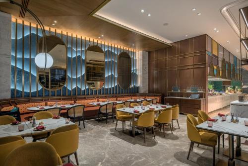 a dining room with tables and chairs at Radisson Blu Hotel & Spa, Nashik in Nashik