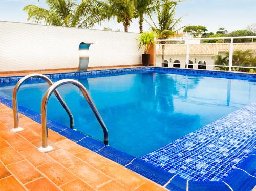 uma piscina com água azul num resort em Hotel KK em Itu