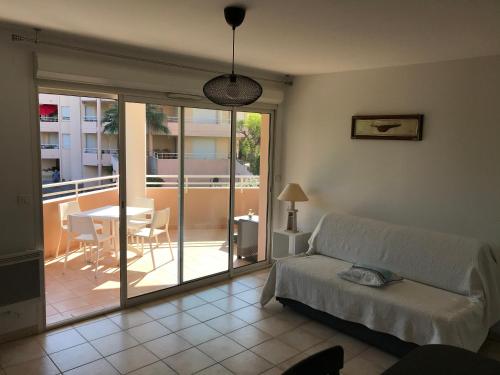 a living room with a bed and a table and a balcony at Les calanques in Cavalaire-sur-Mer