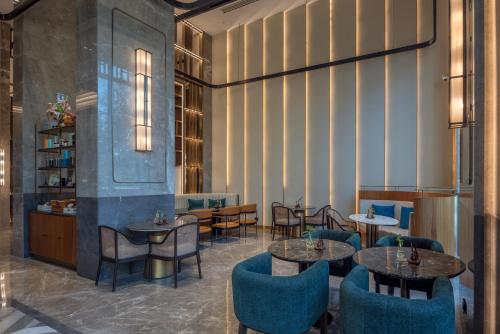 a restaurant with tables and chairs in a room at Radisson Blu Hotel & Spa, Nashik in Nashik