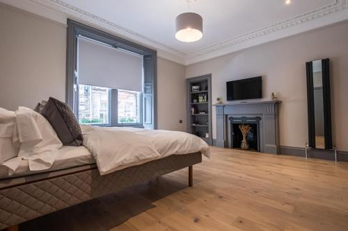 a large bedroom with a bed and a fireplace at The Arran, St Andrews in St. Andrews