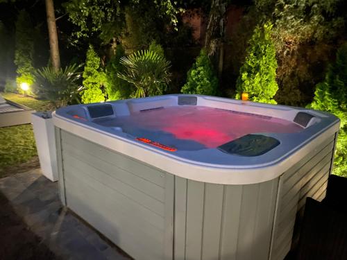 a large jacuzzi tub in a garden at night at Domek w Sosenkach in Osłonin