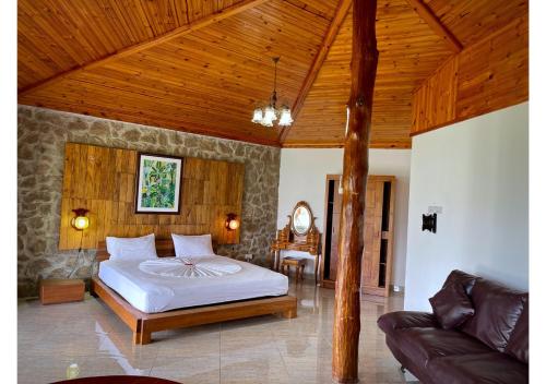 a bedroom with a bed and a couch in a room at Anse Soleil Resort in Baie Lazare Mahé