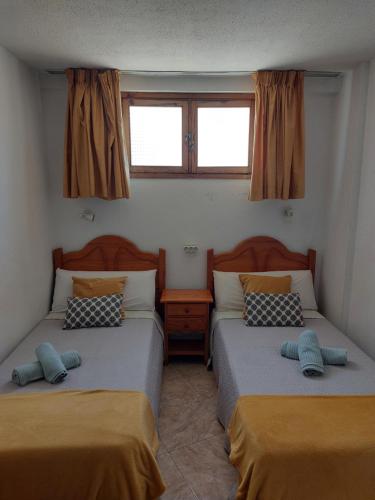2 letti in una camera con 2 finestre di Playa del Ingles Cosy Apartment a Maspalomas