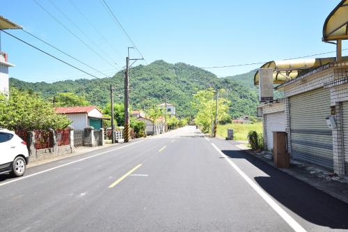 an empty street in a town with mountains in the background at Serenity Moutainview Homestay in Meinong