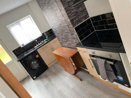 a small kitchen with a washer and dryer and a stove at lovely4 bedroom house close to Loughborough uni/M1 in Loughborough
