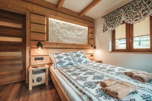 a bedroom with a bed with a wooden wall at Toporowe Izby in Groń