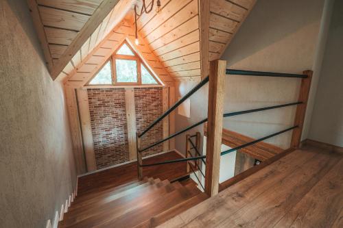 an attic room with a staircase and a window at Toporowe Izby in Groń