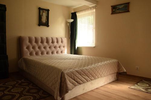 a bedroom with a large bed in a room with a window at Fisherman´s House in Nida