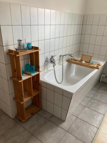 a bathroom with a bath tub with a shower at Ferienhaus Stralsundia in Stralsund