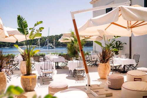 a restaurant with tables and chairs and umbrellas at Hotel Supetar in Cavtat