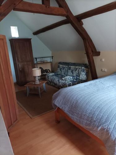 1 dormitorio con 1 cama y 1 sofá en Maisonnette en campagne "Le Rocher" en Vibraye