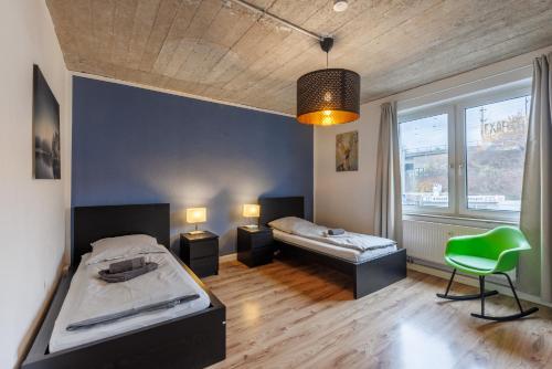 1 dormitorio con 2 camas y silla verde en Glück Auf Monteurswohnungen Schederhofstraße Essen, en Essen