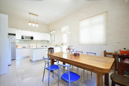 a kitchen with a wooden table and blue chairs at Serenity Moutainview Homestay in Meinong