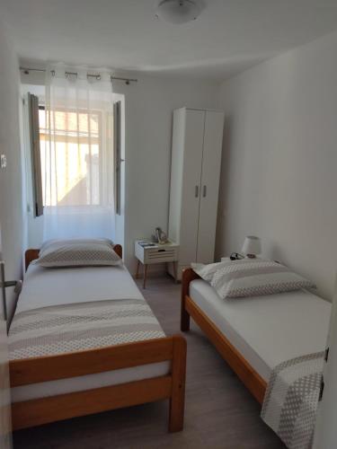 1 dormitorio con 2 camas y ventana en Apartment Zagalo, en Sveta Nedelja