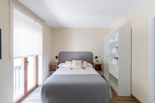 sypialnia z dużym łóżkiem i dużym oknem w obiekcie Housingleón Azabachería 22 w mieście León