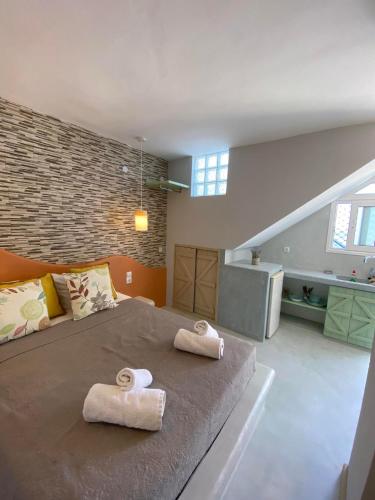 a bedroom with a large bed with two towels on it at MOUSELIS APARTMENTS in Kalymnos