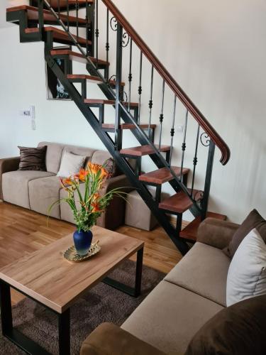 a living room with a staircase and a coffee table at Monix Palace Zlatibor in Zlatibor
