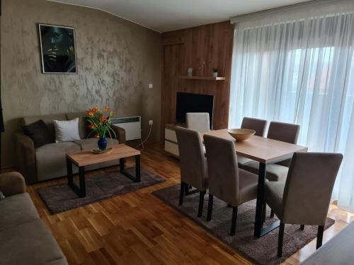 a living room with a table and a couch at Monix Palace Zlatibor in Zlatibor