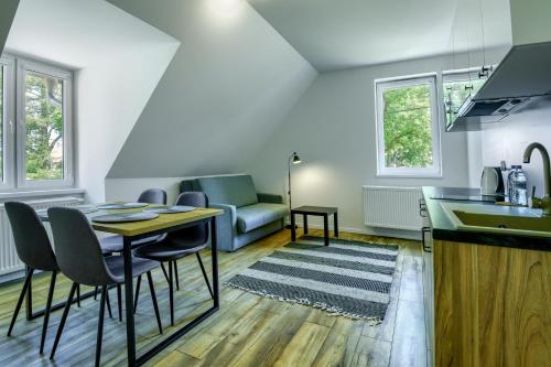 eine Küche und ein Wohnzimmer mit einem Tisch und Stühlen in der Unterkunft Dom Kawalera in Kadyny
