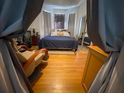 - une chambre avec un lit et une chaise dans l'établissement Room in Guest room - 7privateroom Jacuzzimassage Sitparking15mins2ny, à North Bergen