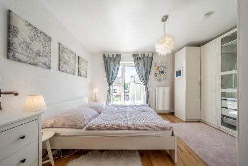 a white bedroom with a bed and a window at Private House in Hannover