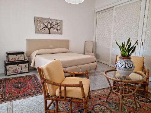 a bedroom with a bed and a table and chairs at La Maison Dorée in Giardini Naxos