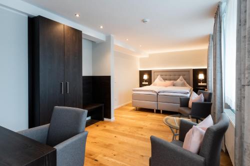a bedroom with a bed and chairs in a room at Landhotel Bartmann in Sendenhorst