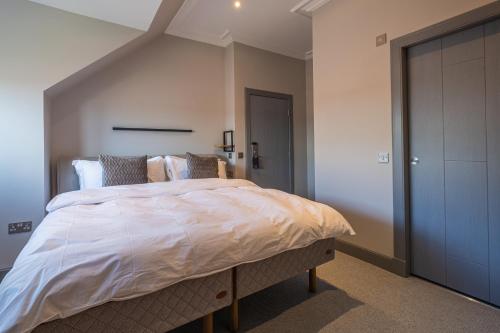 a bedroom with a large bed with white sheets at The Arran, St Andrews in St. Andrews