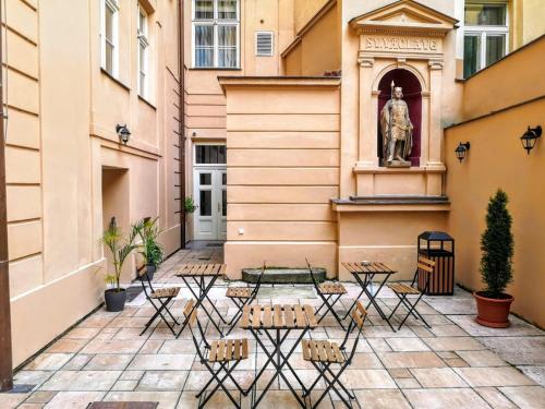 a courtyard with tables and a statue in a building at Quentin Prague Hotel in Prague