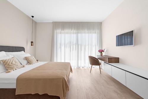 - une chambre blanche avec un grand lit et une chaise dans l'établissement Villa Atena, à Poreč